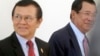 Cambodia's Prime Minister Hun Sen, right, walks with opposition Cambodia Rescue Party Deputy President Kem Sokha, left, during a break at National Assembly in Phnom Penh, Cambodia, Wednesday, Dec. 7, 2016.