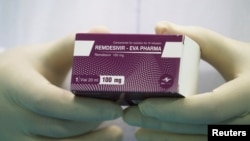 Un technicien de laboratoire tient une boîte du médicament de traitement remdesivir au Caire, en Égypte, le 25 juin 2020. 