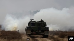 资料照片：乌克兰与波兰军人在波兰希维托舒夫一处军事基地兼试验场训练驾驶豹2坦克。(2023年2月13日)