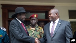 FILE - South Sudan President Salva Kiir, left, and First Vice President Riek Machar, right, shake hands after meetings in Juba, South Sudan, Oct. 20, 2019. Kiir appealed for calm after a U.N. helicopter was attacked and a crew member killed during a Friday rescue mission. 
