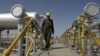 FILE - Iranian oil technician Majid Afshari makes his way to the oil separator facilities in Iran's Azadegan oil field southwest of Tehran, Iran, April 15, 2008.