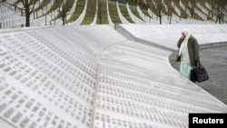 A woman stands near a grave of her family members in the memorial center Potocari before the judges verdict on former Bosnian Serb political leader Radovan Karadzic's appeal of his 40-year sentence for war crimes, near Srebrenica, Bosnia and Herzegovina.