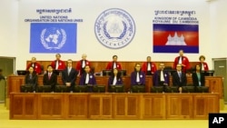 In this photo released by the Extraordinary Chambers in the Courts of Cambodia, Judges and clerks of the U.N.-backed war crimes tribunal are standing inside the court hall of the U.N.-backed war crimes tribunal in Phnom Penh, file photo. 