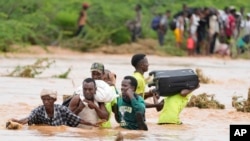 በጎርፍ አደጋ ነዋሪዎች መንገዱን አቋርጠው እየሸሹ 