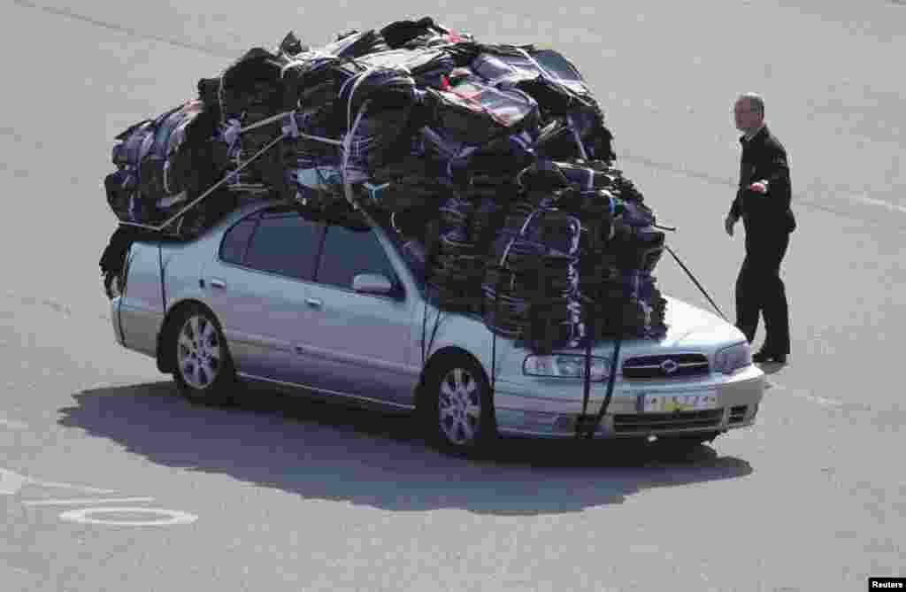 Seorang petugas pabean memeriksa mobil milik sebuah perusahaan Korea Selatan yang memuat produk-produk buatan perusahaan patungan, inter-Korean Kaesong Industrial Complex, di Korea Utara, yang tiba di kantor pabean, imigrasi, dan karantina (CIQ), di sebelah selatan wilayah demilitarisasi yang memisahkan Korea Utara dari Korea Selatan di Paju, sebelah utara Seoul..