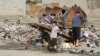 Neighbors collect trash from piles on the street in the hope that government trucks will soon remove the growing stacks of garbage from Mosul, Iraq, Jan. 9, 2017. (H. Murdock/VOA)
