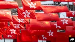 ທຸງ​ຊາດ ຈີນ ແລະ ຮົງ​ກົງ ໃນ​ຂະ​ນະ​ທີ່​ເມືອງ​ດັ່ງ​ກ່າວ​ສະ​ຫຼອງວັນ​ຊາດ ຈີນ ໃນ​ໂຮງ​ກົງ, 1 ຕຸ​ລາ 2023.(AP Photo/Chan Long Hei, File)