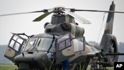 Flight crew of a Z-9WZ attack helicopter, designed and manufactured by China, chat after a flight demonstration for press at a Chinese Liberation Army base, ahead of Army Day on Aug. 1, on the outskirts of Beijing, China Tuesday, July 24, 2012.