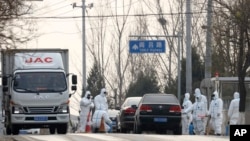 北京郊区房山地区发现非洲猪瘟后，身穿防护服的防疫人员在通往出现疫情的村庄道路上设卡。（2018年11月23日）