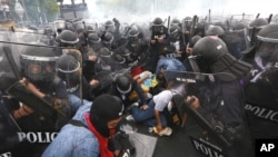 Thai policemen try to arrest anti-government protesters during their clash in Bangkok, Thailand Saturday, Nov. 24, 2012.