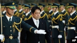 日新防相小野寺五典在东京的日本防卫厅举行的履新欢迎式上检阅仪仗队。(2012年12月27日)