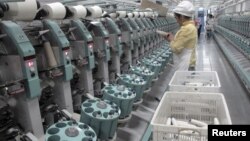 中国新疆阿克苏雅戈尔集团的棉纺织厂工人在工作。（2015年12月1日）