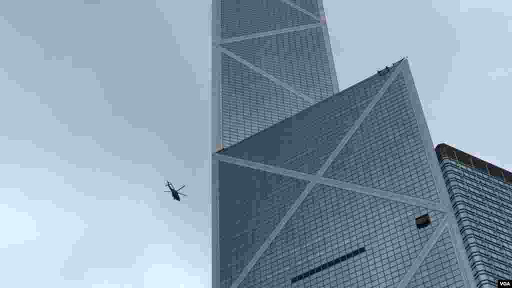 一些穿黑衣的市民到湾仔警察总部外聚集，并在警总外墙上涂鸦。市民遍布从铜锣湾至上环一带的主要干道。警察的直升机在上空盘旋。(2019年8月31日)