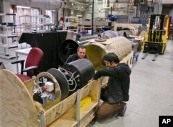 David Kohandash, left, and Mohammad Mousaei work on a robot in the robotics institute at Carnegie-Mellon University in Pittsburgh, April 4, 2018.