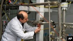یکی از بازرسان آژانس بین المللی انرژی اتمی در حال از کار انداختن سانتریفیوژهای تاسیاست نطنز - ۲۰ ژانویه ۲۰۱۴ 