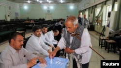 Seorang warga Iran tengah memasukkan surat suaranya ke kotak suara di salah satu TPS di distrik Kadhimiya, Baghdad, 14 Juni yang lalu (Foto: dok). Warga di provinsi Anbar dan Ninewah baru dapat memberikan suara mereka dalam pemilu yang ditunda dua bulan karena alasan keamanan, Kamis (20/6).