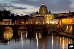 St. Peter's Basilica at the Vatican is seen at dusk across the Tiber River in Rome on Feb. 28, 2025.