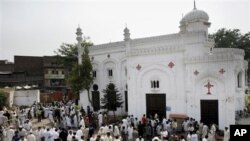 Orang-orang berkumpul di depan sebuah gereja di Peshawar, Pakistan, pasca serangan bom bunuh diri (22/9). 