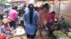 Garment workers buy food along the factory gates in Phnom Penh, Cambodia. (Photo: Khan Sokummono/VOA)