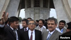 Indian Foreign Minister S.M. Krishna (C) is briefed by Pakistani officials during his visit to the Minar-e-Pakistan in Lahore, Pakistan, September 9, 2012.