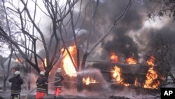 Wazima moto wakiwa wanajitahidi kuzima moto uliotokea baada ya gari la mafuta kupinduka na kuwaka moto nchin Tanzania, Agosti 10, 2019.