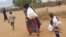 A newly arrived Somali family carry their supply of aid outside Dadaab, Eastern Kenya, 100 kms (60 miles) from the Somali border, Aug. 5, 2011. (AP)