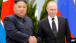 Le président russe Vladimir Poutine, à droite, et le leader de la Corée du Nord, Kim Jong Un, se serrent la main, avant leur entretien à Vladivostok, en Russie, le jeudi 25 avril 2019.