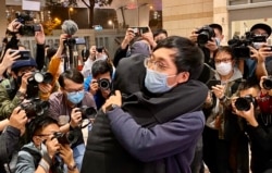 有被告家属得知保释申请被拒绝，在法院大楼外抱着元朗区议员林进痛哭（美国之音/汤惠芸）