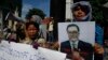 A Cambodian opposition party supporter, right, holds a portrait photo of an opposition senator Hong Sok Hour during a protest in front of the Phnom Penh Municipal Court, in Phnom Penh, Cambodia, Saturday, Aug. 15, 2015. 