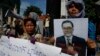 A Cambodian opposition party supporter, right, holds a portrait photo of an opposition senator Hong Sok Hour during a protest in front of the Phnom Penh Municipal Court, in Phnom Penh, Cambodia, Saturday, Aug. 15, 2015. 
