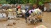 Local residents carry their belongings as they evacuate their homes in Niamey, the capital of Niger, on August 19, 2012. 
