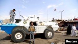 Petugas keamanan berjaga-jaga di lokasi serangan bom mobil di Baghdad (26/8). 
