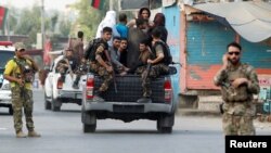 نیروهای امنیتی افغانستان زندانیان فراری بازداشتی پس از حمله شورشیان به ساختمان زندان در جلال آباد را جا به جا می کنند. 