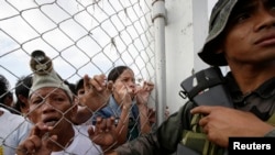 Warga mengantre obat dan bantuan di bandar udara Tacloban (11/11). (AP/Bullit Marquez)