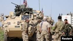 지난 2017년 4월 시리아 터키 접경 다르바시야 마을에서 미군과 미군의 지원을 받는 YPG(쿠르드인민수비대) 대원들이 대화하고 있다.