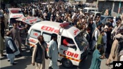 Warga berunjuk rasa sambil mengikuti ambulan yang mengangkut jenazah korban pembajakan dua bis di Quetta, Pakistan (30/5). 