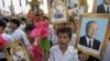 Cambodian students hold portraits of former King Norodom Sihanouk during an Independence Day celebration in Phnom Penh, Cambodia, Nov. 9, 2011.