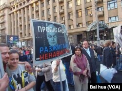 去年秋季莫斯科市中心的反战游行中，示威者手举标语：宣传煽动仇恨。背景人头像是今日俄罗斯传媒集团总裁和电视政论主持人基西廖夫 (美国之音白桦拍摄)