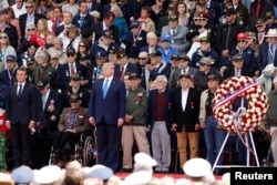 French President Emmanuel Macron and U.S President Donald Trump stand during a ceremony to mark the 75th anniversary of the D-Day at the Normandy American Cemetery and Memorial in Colleville-sur-Mer, France, June 6, 2019.