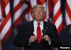 FILE - Republican U.S. presidential candidate Donald Trump adjusts his jacket as he speaks at the Republican National Convention in Cleveland, Ohio, July 21, 2016.