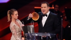 FILE - Host Norm Macdonald removes a pancake from a spoof "swag bag" at the 2016 Canadian Screen Awards in Toronto, Ontario, March 13, 2016.