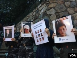 25일 미국 워싱턴에서 열린 북한자유주간 행사에서 중국의 강제북송을 규탄하는 시위대가 북송된 북한 주민들의 사진을 들고 있다.