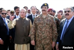 In this Nov. 13, 2016 photo, Pakistan's Prime Minister Nawaz Sharif and Army Chief of Staff General Raheel Sharif, right, attend the inauguration of a port in Gwadar, Pakistan.