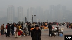 2013年2月，重庆居民在朝天门公园，背景是新建的社会保障房。薄熙来由于社会保障房等项目而在当地得人心，但也留下巨额债务