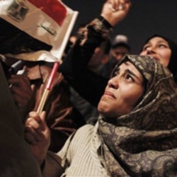 An Egyptian woman among many celebrating in Tahrir Square in Cairo
