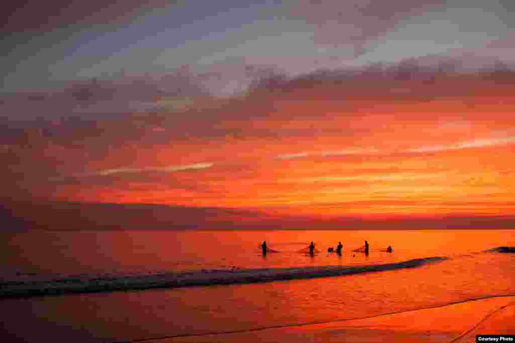 Nelayan di Kuakata menyebar jaring mereka saat matahari terbenam di Bangladesh. (Foto oleh Dennis Cohen / Inggris dikirmkan untuk Kontes Foto VOA)