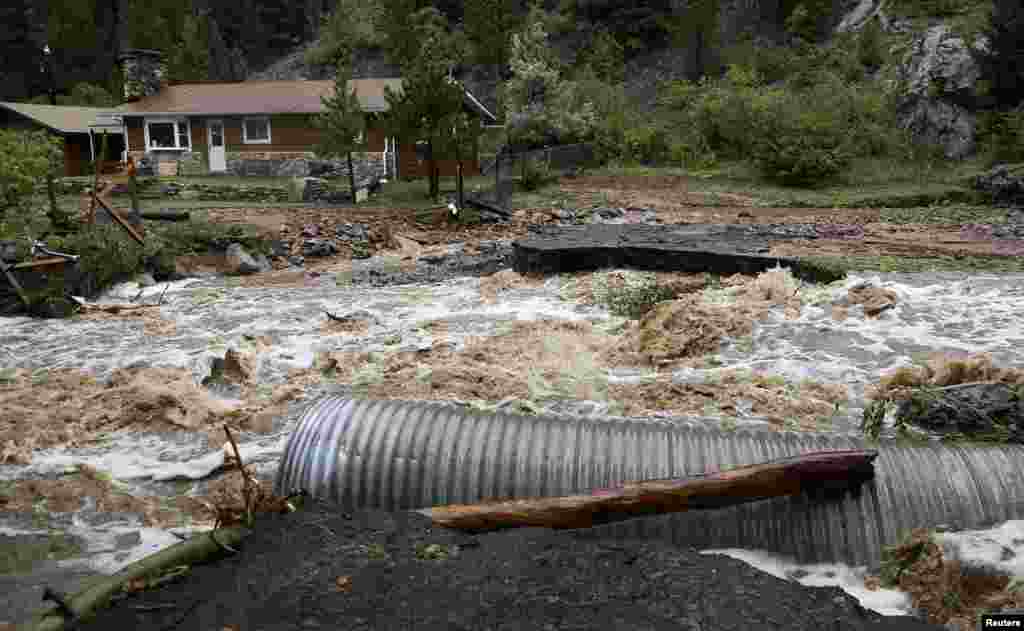 Sebuah rumah terjebak banjir di Coal Creek dekat Golden, Colorado (12/9).