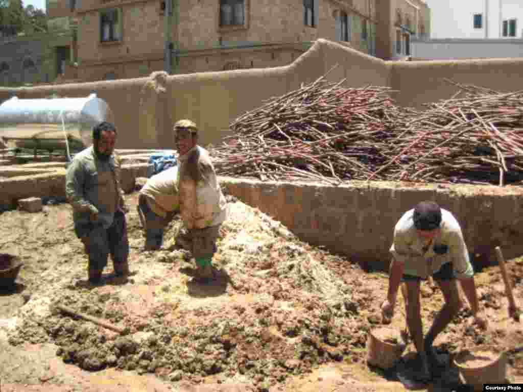 Workers preparing the mud for plaster. (Photo courtesy AIYS)