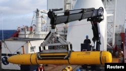 澳大利利亚海军“海盾号”上的人员将美国海军的“蓝鳍-21”放置印度洋海底搜寻失踪马航MH370班机。（2014年4月14日）