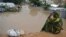 A woman living at a camp for the internally displaced sits on high ground above a flooded street on May 20, 2018 in Mogadishu after temporary shelters were inundated in Somalia's capital following heavy overnight rainfall. 